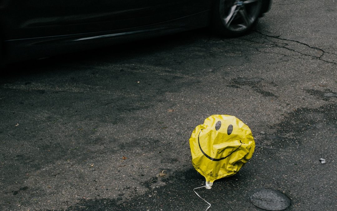 Image of a deflated smiley face baloon