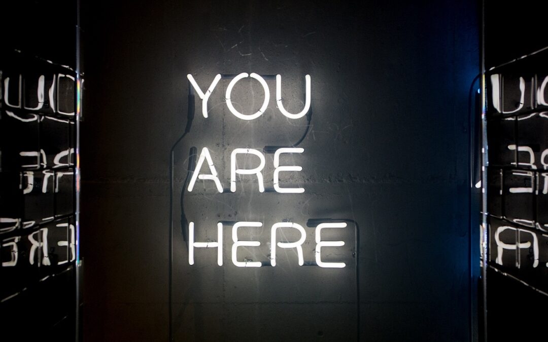 Image of a neon sign that says "You are here".
