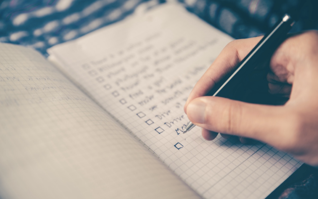 Image of a hand writing a checklist.