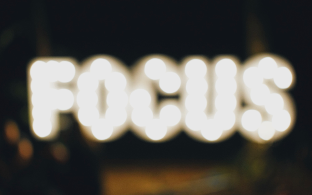 Image of the word "FOCUS" spelled out in lights, but it's out of focus